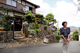 庭先を手入れしてひと休み。高台にある家からは、里山が見渡せる