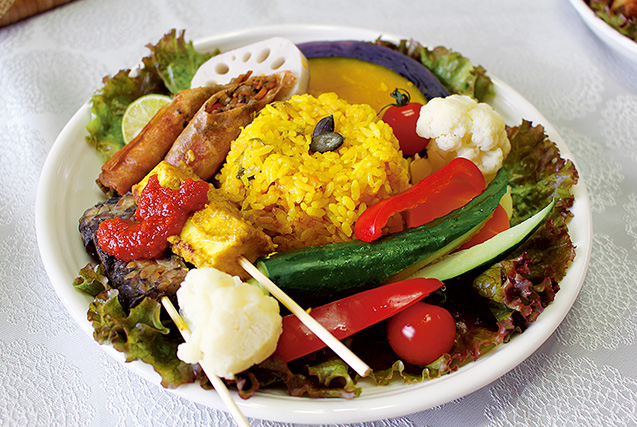 旬の野菜にピラフや春巻き、厚揚げの串焼きなどを盛りつけたノーミートのインドネシア料理