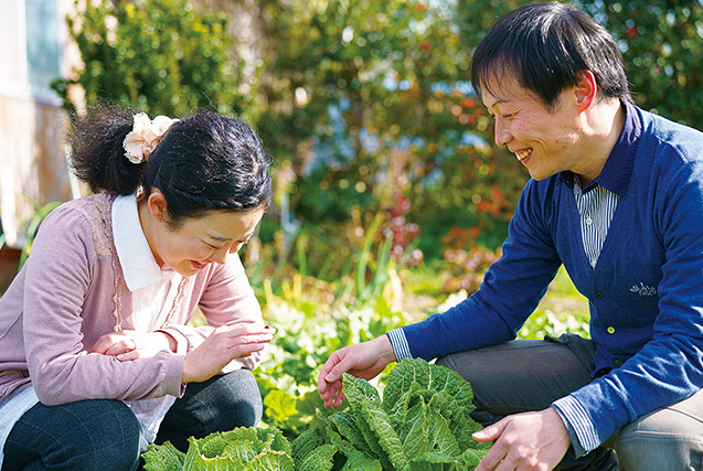 自宅の隣にある畑で。夫の秀治さんが久世さんに指先から指先へてんとう虫を渡すと、2人は顔を見合わせて微笑んだ