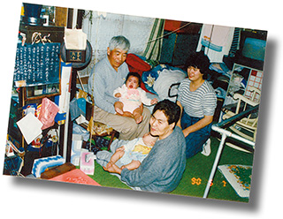 幼い頃の亜衣さん(中央奥)を抱く、曾祖父の岡川勝蔵さん。手前は曾祖母のヂョウさん、右は亜衣さんの母親の久美子さん