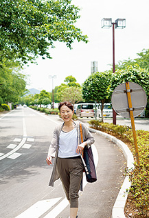 ヨガマットを肩に掛け、軽快な足取りで通りを歩く川島さん