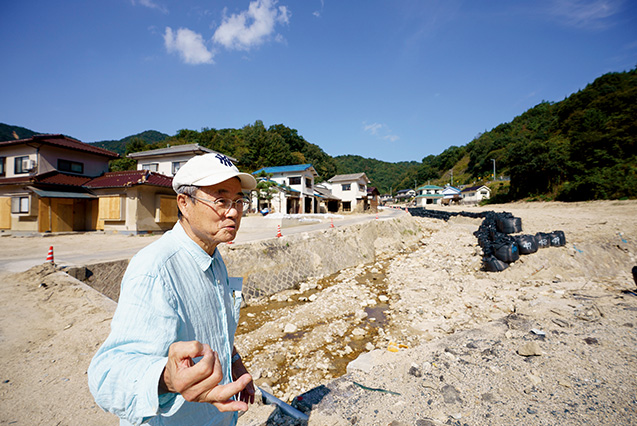 吉川三郎(よしかわ・さぶろう)さん│71歳│広島県坂町(さかちょう) 「普段は水量も少なく穏やかな天地川が氾濫し、住宅が流されました。ここにも、アパートや家屋が建っていたんですよ」と語る吉川さん 取材/多田茂樹 写真/堀 隆弘