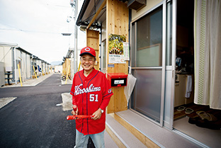 広島カープファンの吉川さん。赤い野球帽とユニフォームで、周囲の人たちを元気づけている