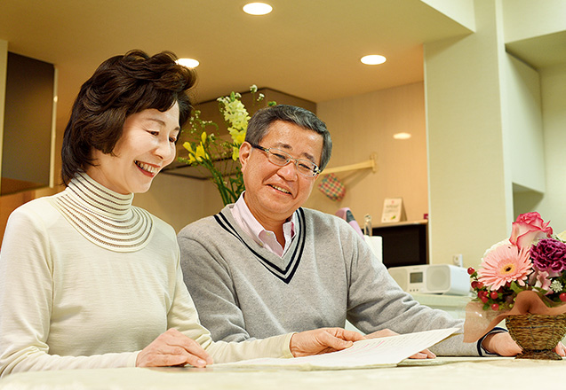長手幸子(ながて・さちこ)さん (55歳)川崎市中原区 長男の啓さんが信仰について思索したノートを、夫の優さんと見つめる 取材/水上有二(本誌) 撮影/遠藤昭彦