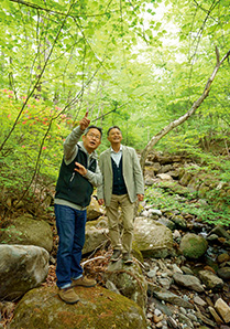 新緑が目に鮮やかな自宅近くの清里の森で、清里の自然の魅力について語る川嶋さん