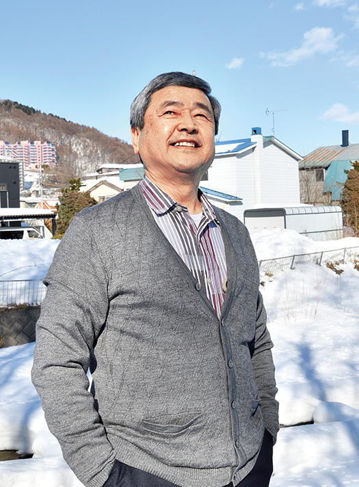 田村 修（たむら・おさむ）さん│70歳│札幌市南区 札幌市の自宅裏にある家庭菜園の前で。「雪が解けたらまた無農薬野菜を作ります」 取材／佐柄全一　写真／加藤正道