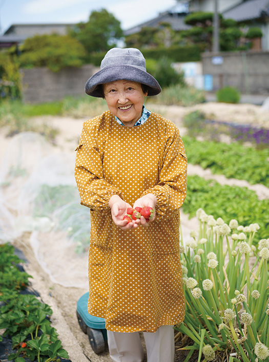 畑でとれたイチゴを手に笑顔の藤井ヒロミさん 取材/久門遥香(本誌) 写真/堀 隆弘