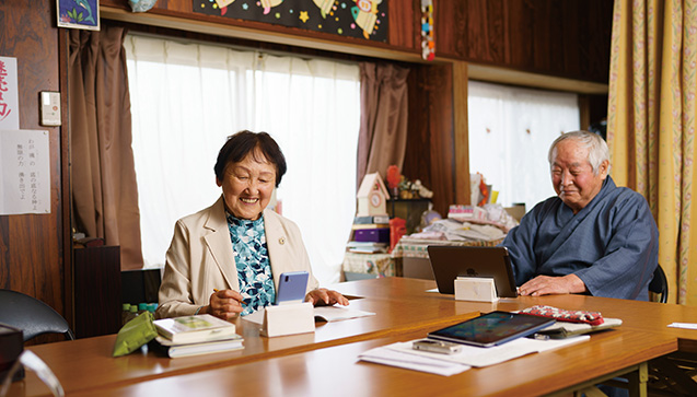 自作のスマホ・タブレットスタンドを使うヒロミさんと夫の祥孝さん