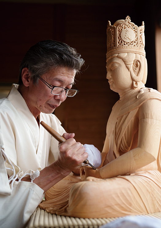 藤崎秀平さん│62歳│富山県南砺市 純白の作業着で大日如来像を彫る。「仏像を彫り参らせることは、私の一つの祈りです」 取材/佐柄全一 写真/堀 隆弘