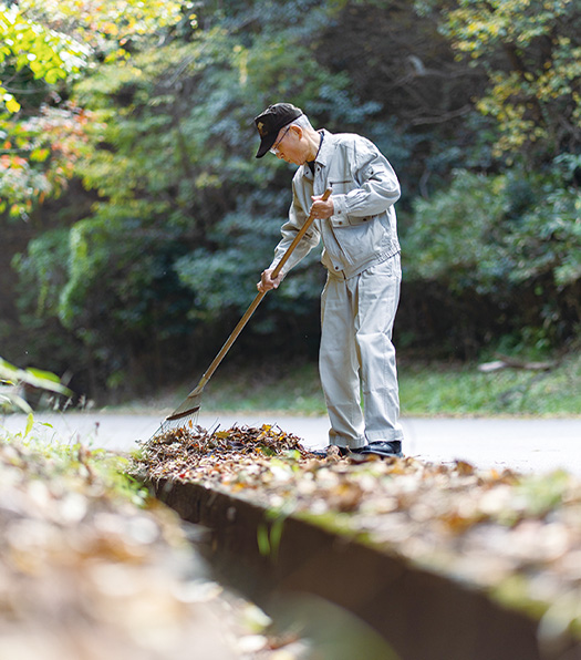 落ち葉を掻き集め、側溝の泥やゴミも丁寧にさらう。「今は、ただ感謝の思いでさせていただいています」（写真／髙木あゆみ）