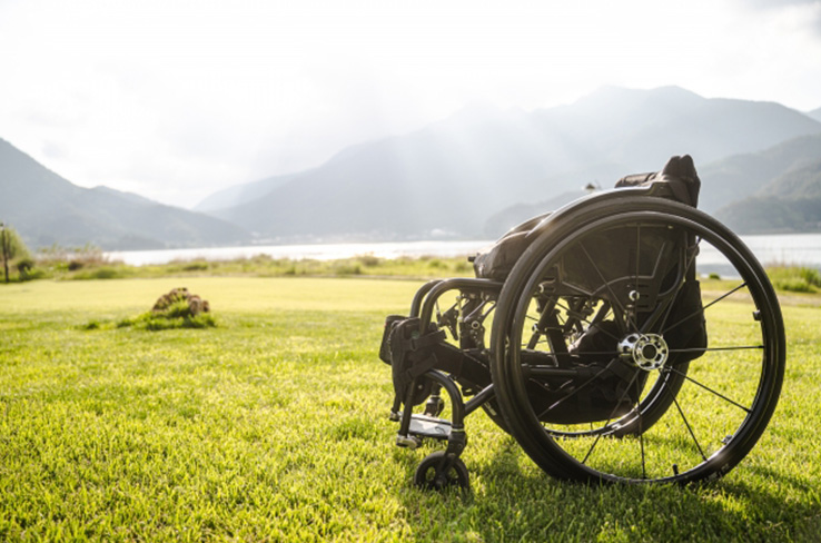 商店街で車椅子をこぐ英幸さんに、ゆかりさんが後ろからそっと手を添える（写真／髙木あゆみ）