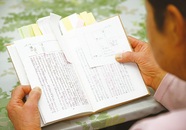 『生命の實相』を拝読する伏木さん。付箋の多さから熟読しているのが伝わってくる(写真/永谷正樹)