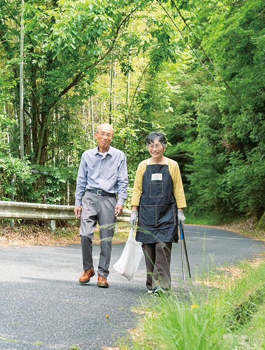 自宅の近くの道を、ゴミ拾いのトングと袋をもって誠治さんと散歩する
