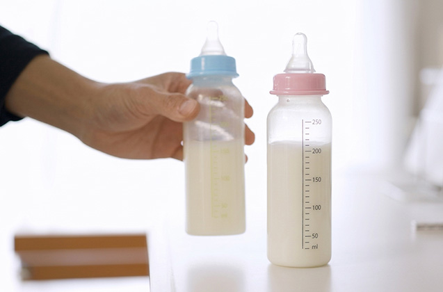 手に持った哺乳瓶と、並べて置かれた哺乳瓶